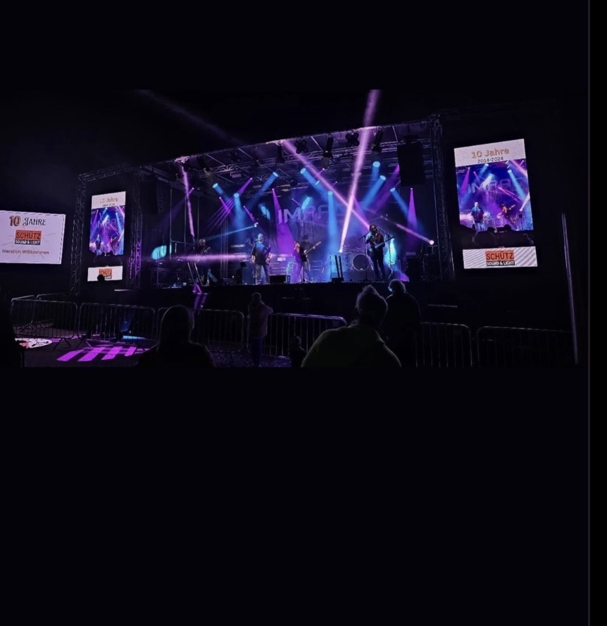 Liveband auf einer beleuchteten Bühne mit Videowänden